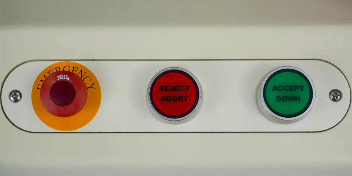 Close up of buttons on a test system - emergency, reject abort, accept down.