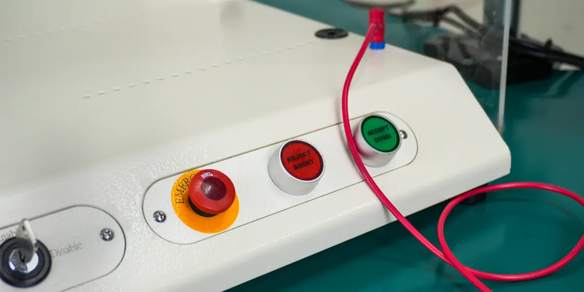 3 buttons - emergency, reject abort, accept down and an enable/disable key on a ICT Test System